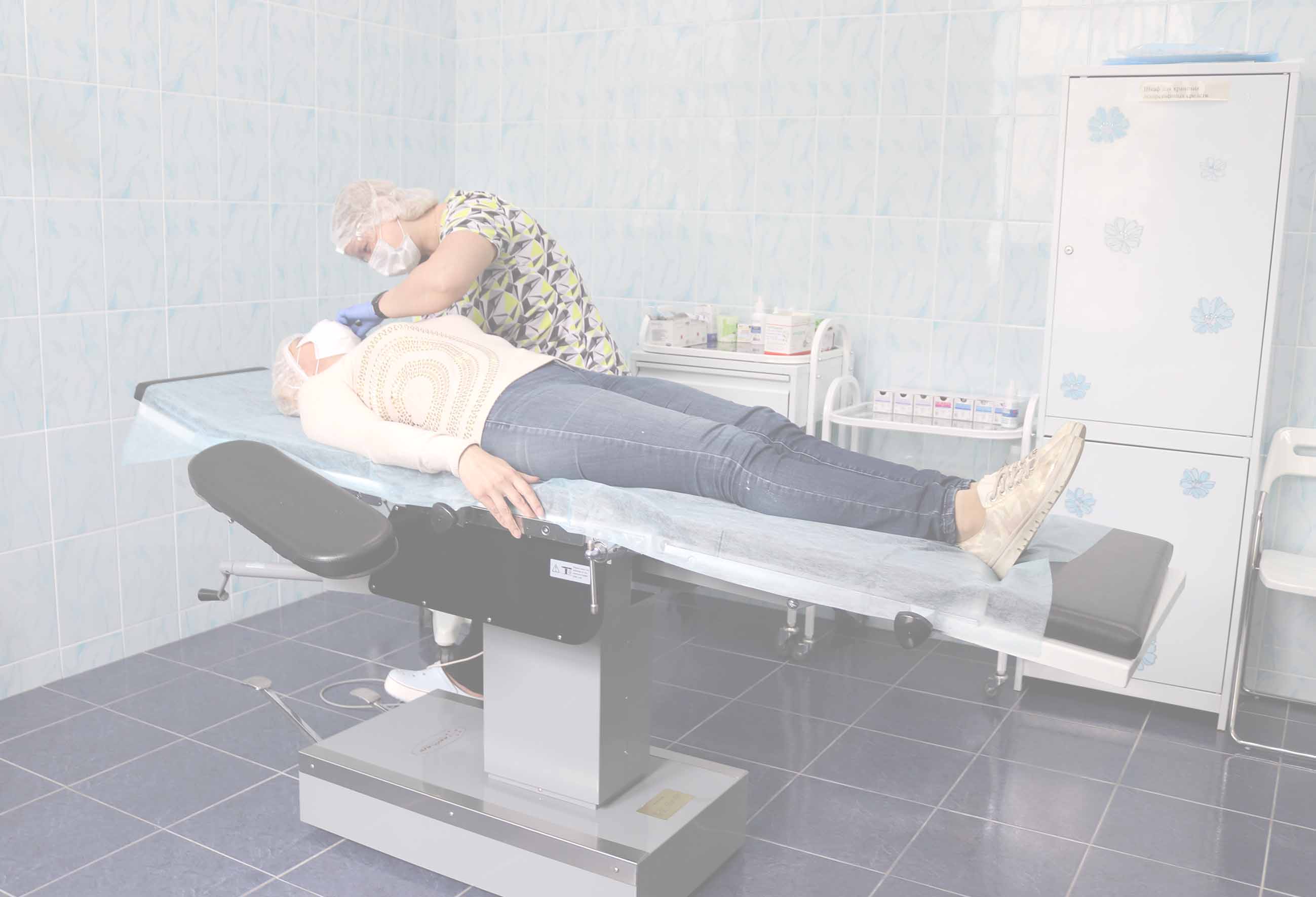 Девушка лежит на кушетке и ее лечит врач