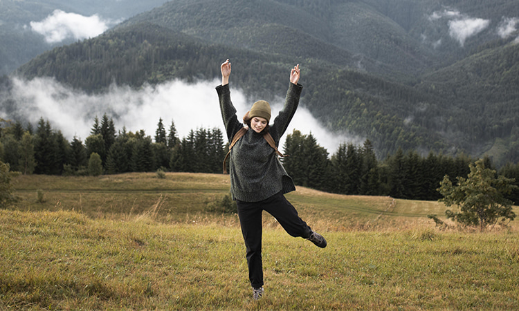 Девушка танцует на фоне гор